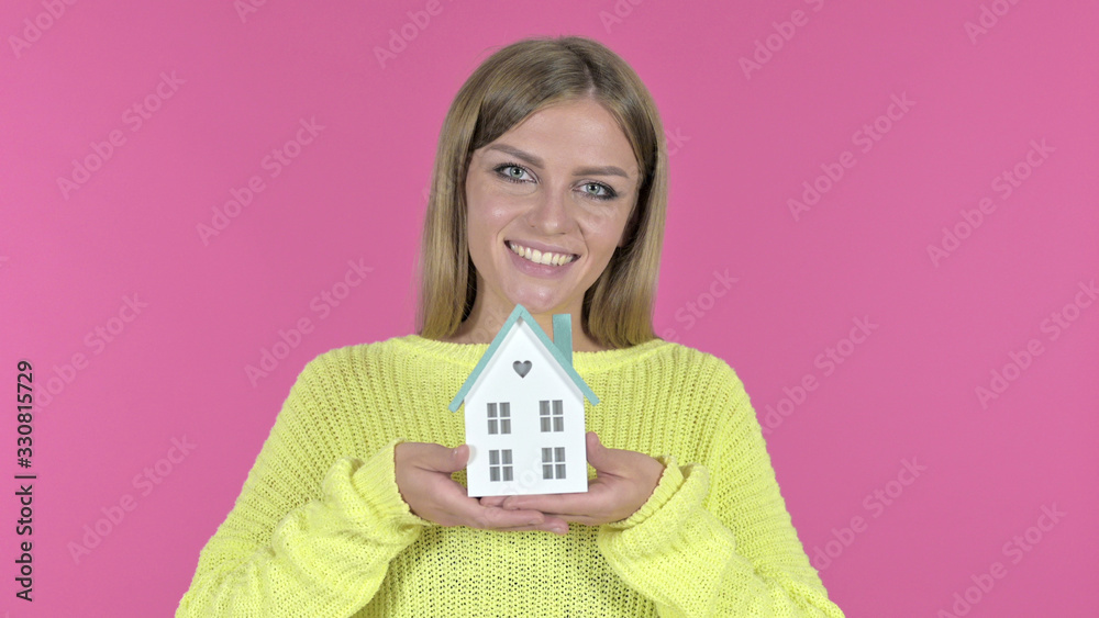 Beautiful Young Girl holding Model House, Pink Background Beautiful Young Girl holding Model House, Pink Background