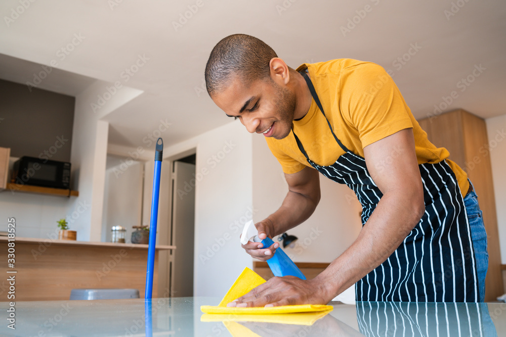 Young latin man cleaning at home. Young latin man cleaning at home.