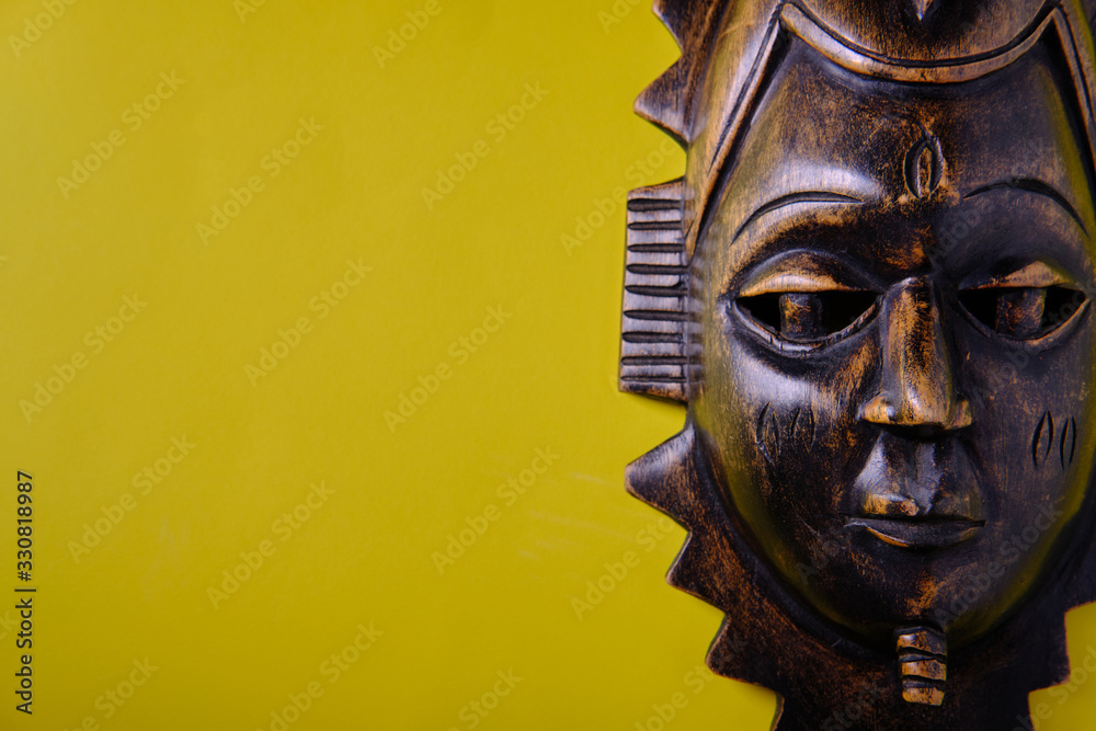 Wooden african mask on a yellow background
