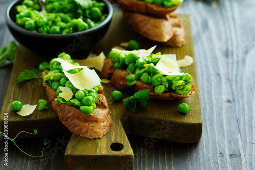 Crostini with pea puree, mint and parmesan. Snack.