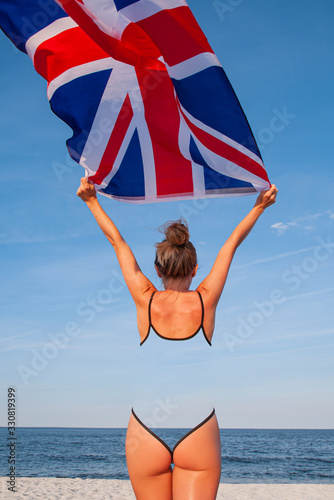 National Flag of United kingdom. Beautiful woman with british flag on the beach.