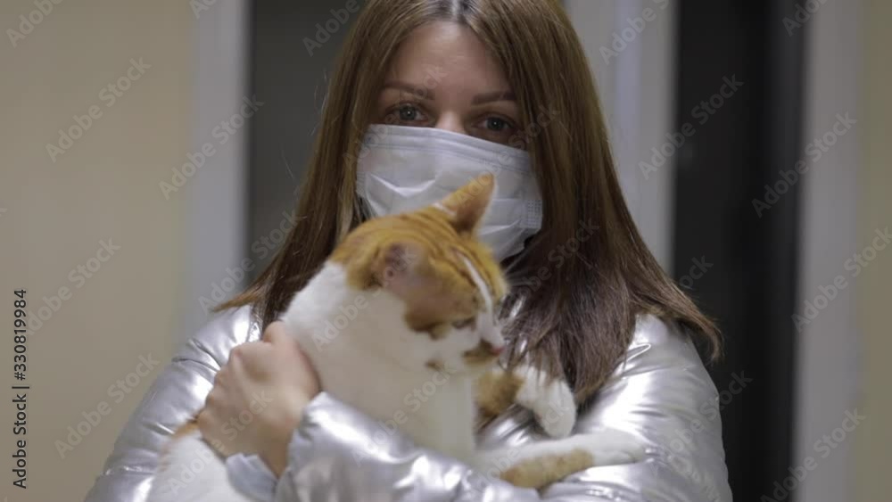 Girl in a mask with a domestic cat emerges from the veterinary clinic Girl in a mask with a domestic cat emerges from the veterinary clinic