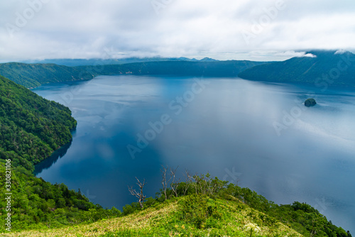 Natural landscape from Lake Mashu viewing platform. The lake surface often obscured by fog in summer season, given the lake a reputation for mysteriousness. Akan Mashu National Park, Hokkaido, Japan photo