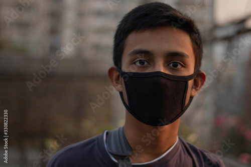 Helpless boy is wearing a mask to prevents corona virus and air pollution dust