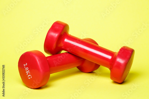 red sports dumbbells on a yellow background