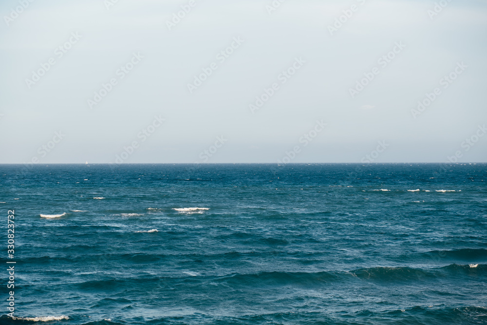 Blue sea with waves and cloudy sky background. Seascape background for design.