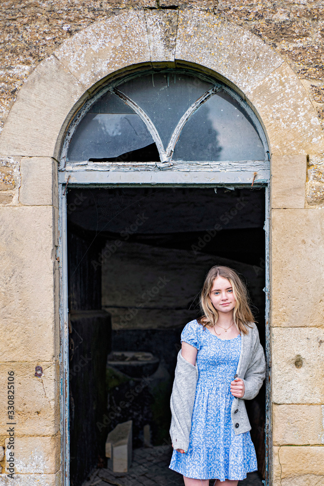 Girl standing in an old country barn door