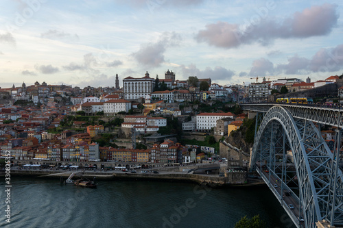 Porto, Portugal - 09/25/2019: Porto view, with Dom Luís Bridge and metro. Sunset, blue sky and clouds. Boats on the river