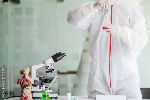 The medical team wore a coronavirus protective suit and rubber gloves to examine the coronavirus covid-19 and research for a vaccine to prevent coronavirus covid-19 to stop the epidemic photo