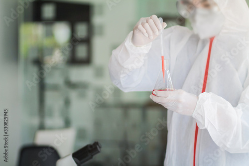 The medical team wore a coronavirus protective suit and rubber gloves to examine the coronavirus covid-19 and research for a vaccine to prevent coronavirus covid-19 to stop the epidemic photo