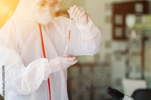 The medical team wore a coronavirus protective suit and rubber gloves to examine the coronavirus covid-19 and research for a vaccine to prevent coronavirus covid-19 to stop the epidemic photo