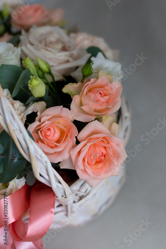 Pastel trend colored flowers in white basket isolated  selective focus