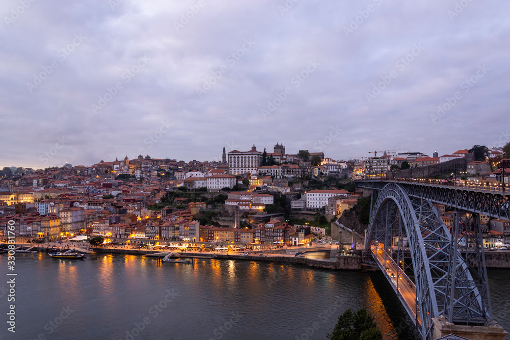 Porto, Portugal - 09/25/2019: Porto view, with Dom Luís Bridge and metro. Sunset, blue sky and clouds. Boats on the river