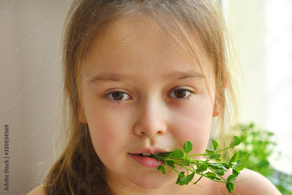 Happy girl eats pea microgreen .vegeterian concept.good appetite. spring avitaminosis.sprout vegetables germinated from high quality organic plant seed on linen mat.superfood Happy girl eats pea microgreen .vegeterian concept.good appetite. spring avitaminosis.sprout vegetables germinated from high quality organic plant seed on linen mat.superfood