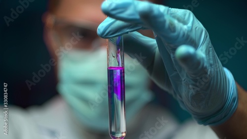 Fotografie scientist pouring chemical substance into test tube, observing reaction