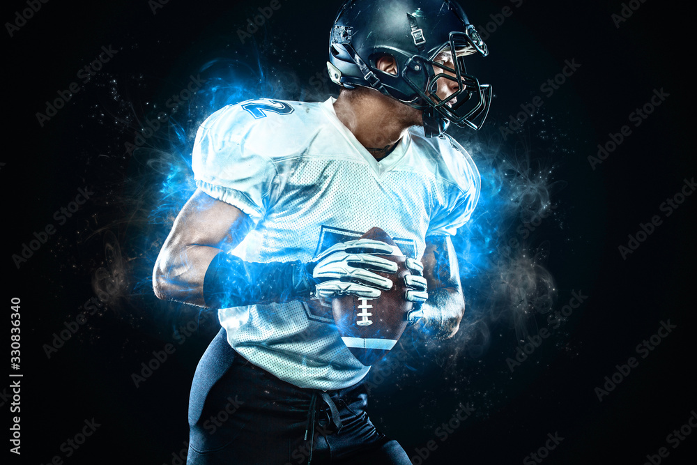 American football player in helmet with ball in hands. Fire background.  Team sports. Sport wallpaper. Stock Photo | Adobe Stock