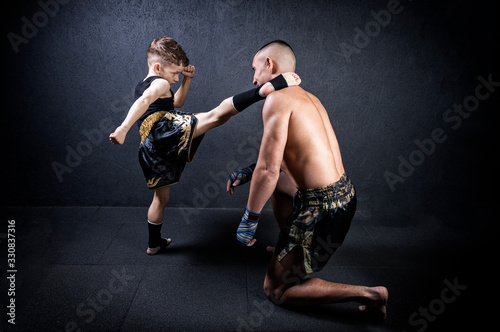 Kickboxing coach is training the boy. The concept of family, sports, mma, muay thai. photo