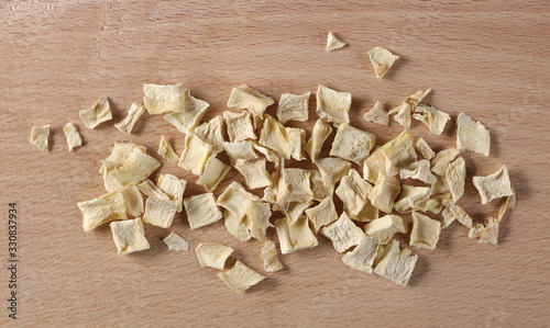 Pile dry chopped parsnip root on wooden chopping board background and texture