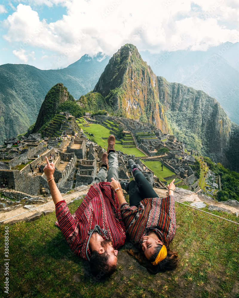 Φωτογραφία Watch this! Happy young tourist couple are on vacation, with ponchos in Machu P