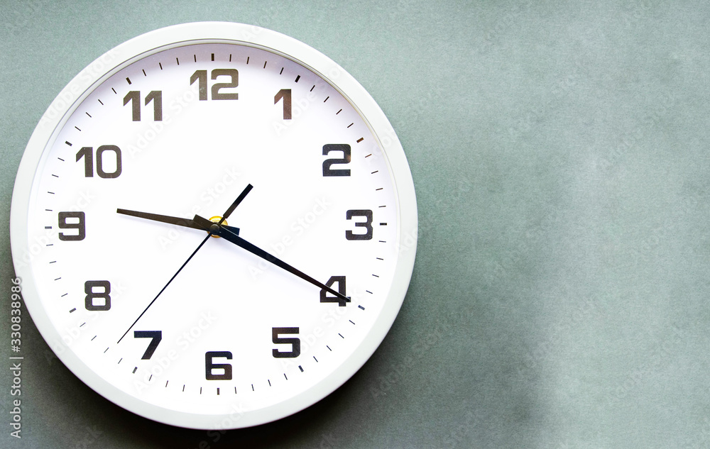 Analog white clock on a gray background. Large numbers and arrows. Clock in close-up. Place for text. Business, are you ready? Analog white clock on a gray background. Large numbers and arrows. Clock in close-up. Place for text. Business, are you ready?