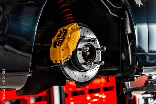 Nahaufnahme einer Bremsscheibe am Auto die vom Service der Werkstatt gewechselt wird photo
