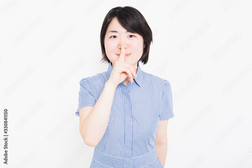 内緒のポーズをするワンピースを着た女性 内緒のポーズをするワンピースを着た女性