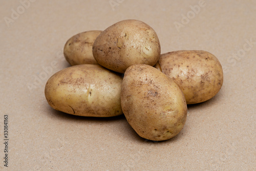 raw dirty potatoes on a craft color background