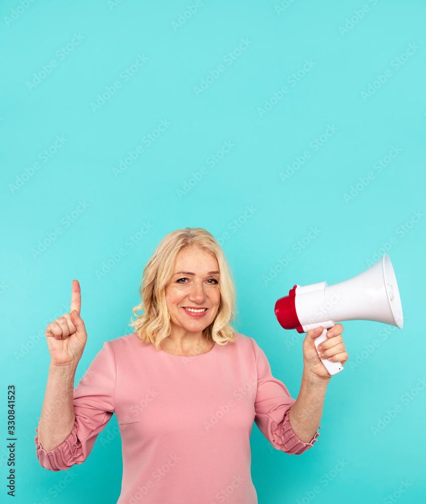 Naklejka premium Cute blond mid woman speak in the megaphone isolated over the blue background