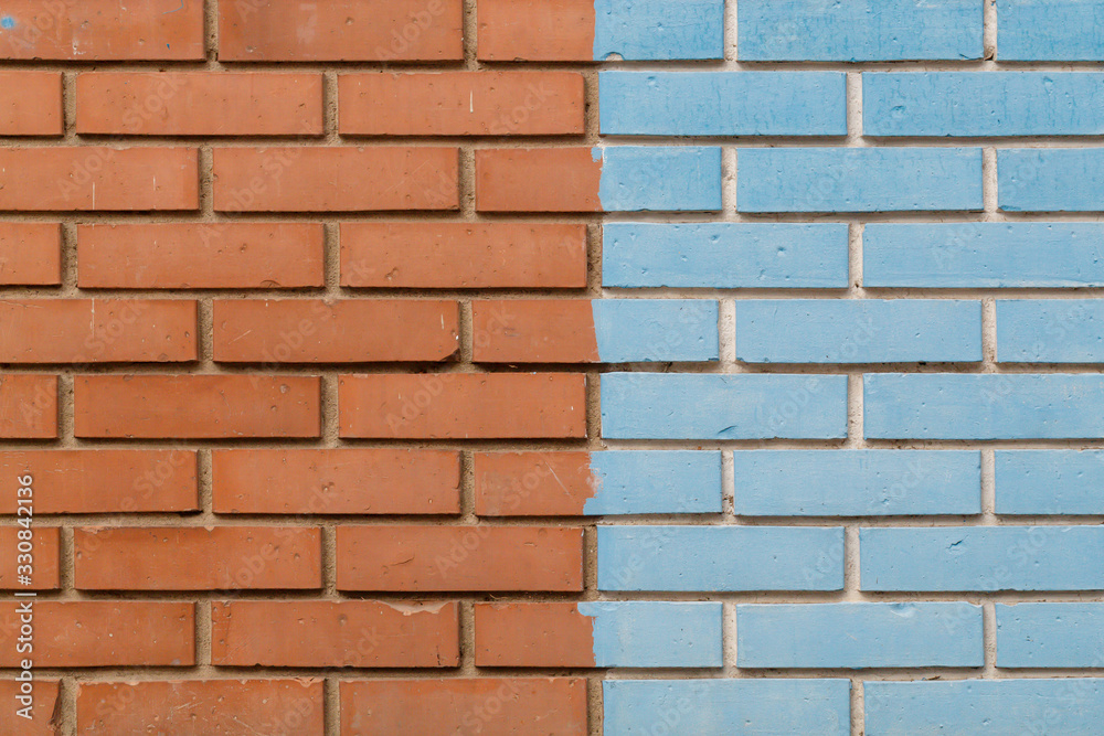 Obraz premium Half Orange Half Blue Painted Brick Wall