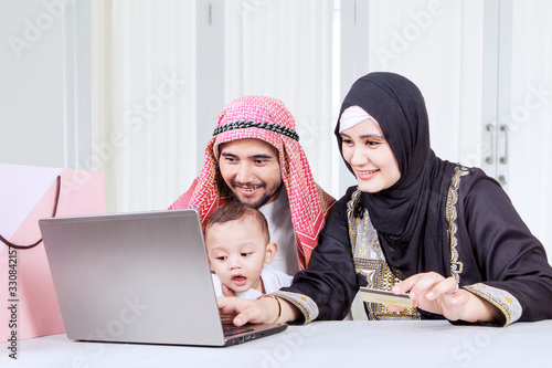 Attractive muslim family online shopping together