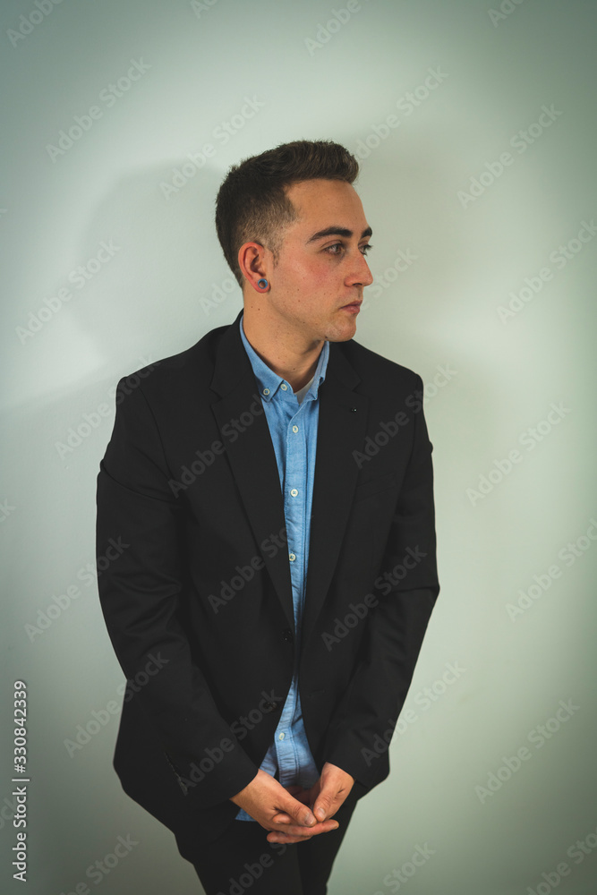 sesion de interior a un chico joven elegante y trajeado con tatuajes en el brazo, haciendo poses, mirando a la cámara, al móvil y en varias poses sesion de interior a un chico joven elegante y trajeado con tatuajes en el brazo, haciendo poses, mirando a la cámara, al móvil y en varias poses