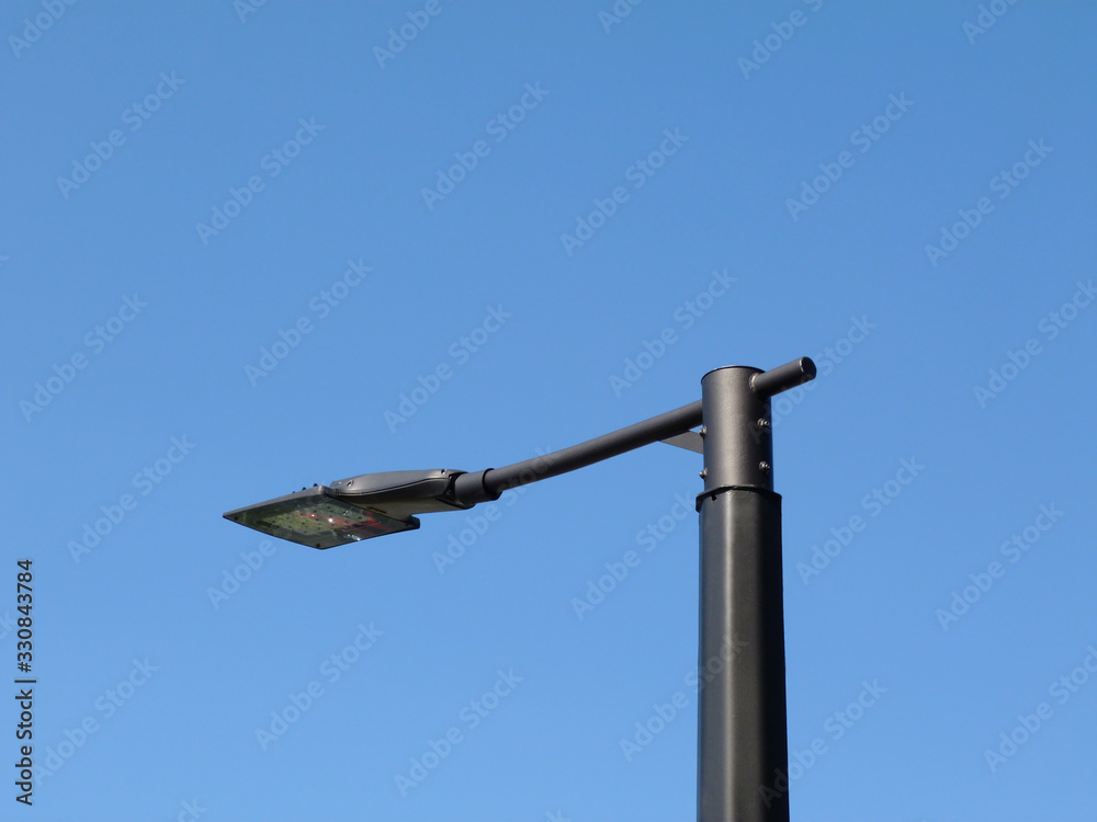 abstract perspective view of modern street light with square LED lamp head. blue sky in perspective view on pewter color tubular light pole. blue sky background. street lighting technology concept abstract perspective view of modern street light with square LED lamp head. blue sky in perspective view on pewter color tubular light pole. blue sky background. street lighting technology concept