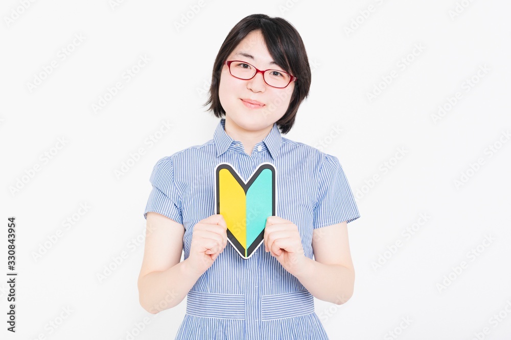 初心者マークを持つワンピースを着た女性 初心者マークを持つワンピースを着た女性