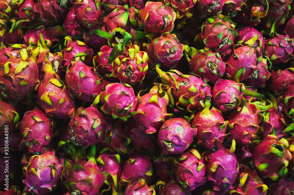Plenty of fresh pitahaya fruits on a counter in a market