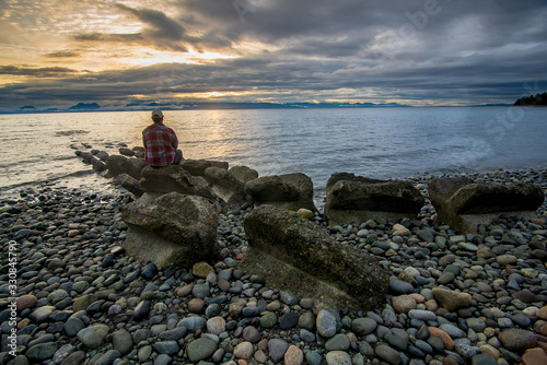 Man checking out the sunrise at Miracle beach provincial park, Comox Valley, Vancouver Island, British Columbia, Canada.
