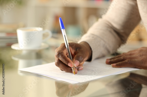 Black man hands filling out form on a desk
