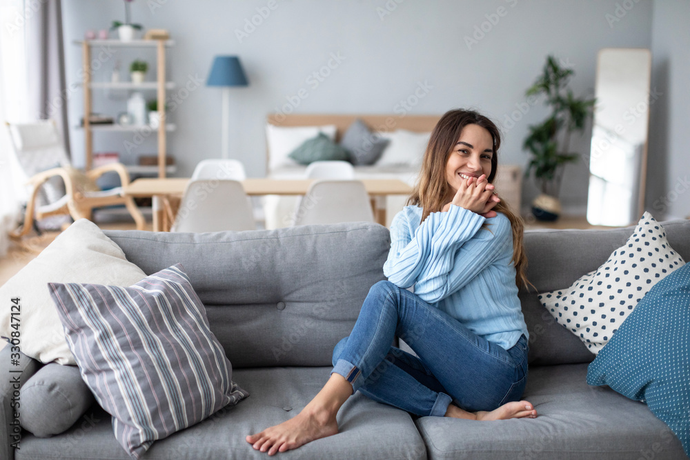 Relaxed smiling woman sitting on sofa at home. Relaxed smiling woman sitting on sofa at home.