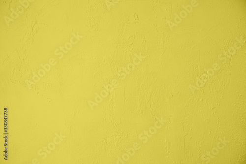 Saturated yellow colored low contrast Concrete textured background with roughness and irregularities. 2020, 2021 color trend.