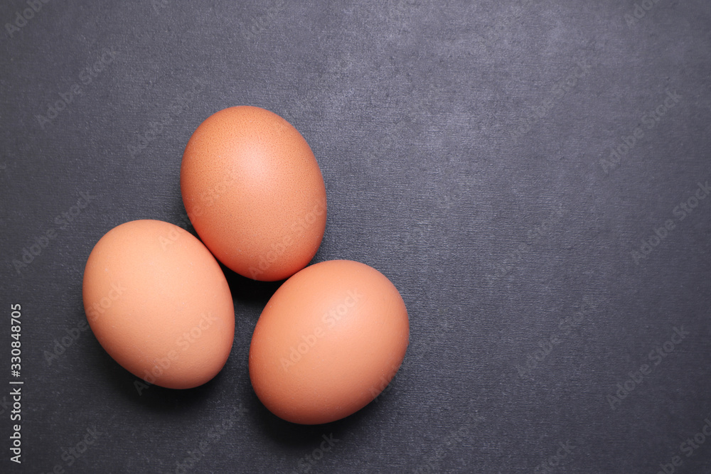 Chicken eggs on a black textured background. Chicken eggs on a black textured background.