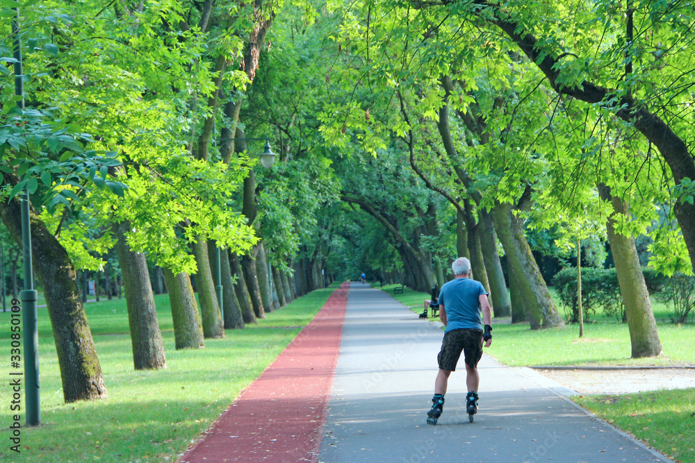 Beautiful city park with treadmill and man running on roller skates