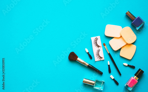 Professional makeup tools. Makeup tools brushes, nail polish, creme ,cotton pads, aplicators on blue pastel background. Cosmetics for beauty.Top view with copy space Flat lay.