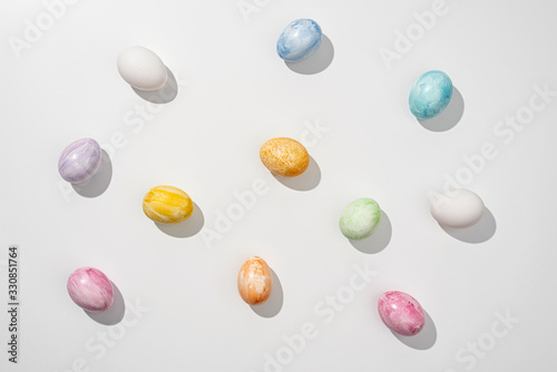 Multicolored colorful easter eggs on a white surface. Top view.