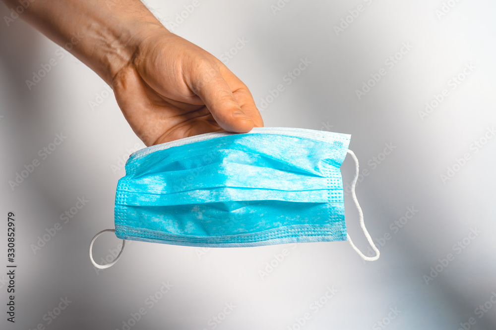 Protective face mask in hand. Surgical mask. Medical mask and corona virus protection.