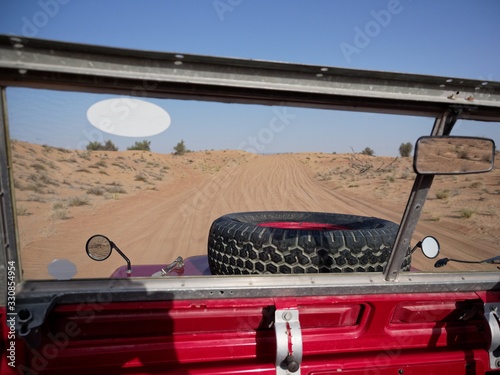 Driving through dunes in a vintage off-road vehicle