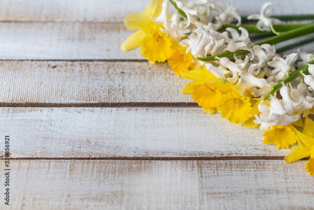 yellow daffodils and white hyacinths flowers on a white wooden background in springtime