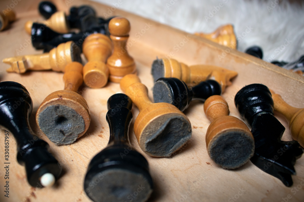 Chess pieces into old wood chessboard on a white carpet Chess pieces into old wood chessboard on a white carpet