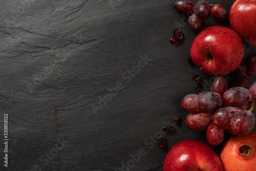 Summer abstract creative trendy fresh concept. Red fruits background, dark stone slake plate with copy space. Flat lay top view. photo