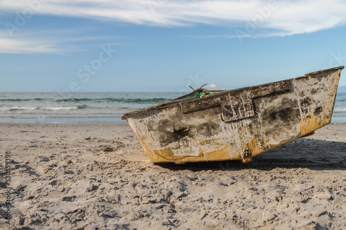 Weathered boat lying on the sand, Onetangi beach, New Zealand
