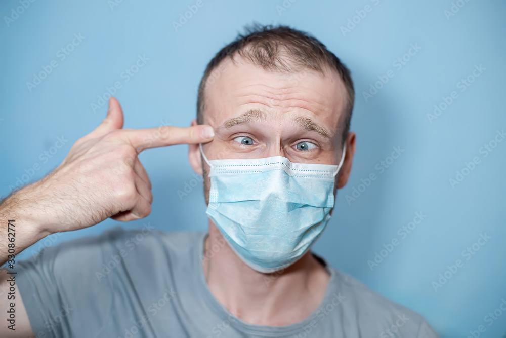 man in protective mask put finger to temple like suicide. guy in medical mask putting, holding pistol figure with fingers. hild with flu, influenza, coronavirus or cold protected from viruses man in protective mask put finger to temple like suicide. guy in medical mask putting, holding pistol figure with fingers. hild with flu, influenza, coronavirus or cold protected from viruses