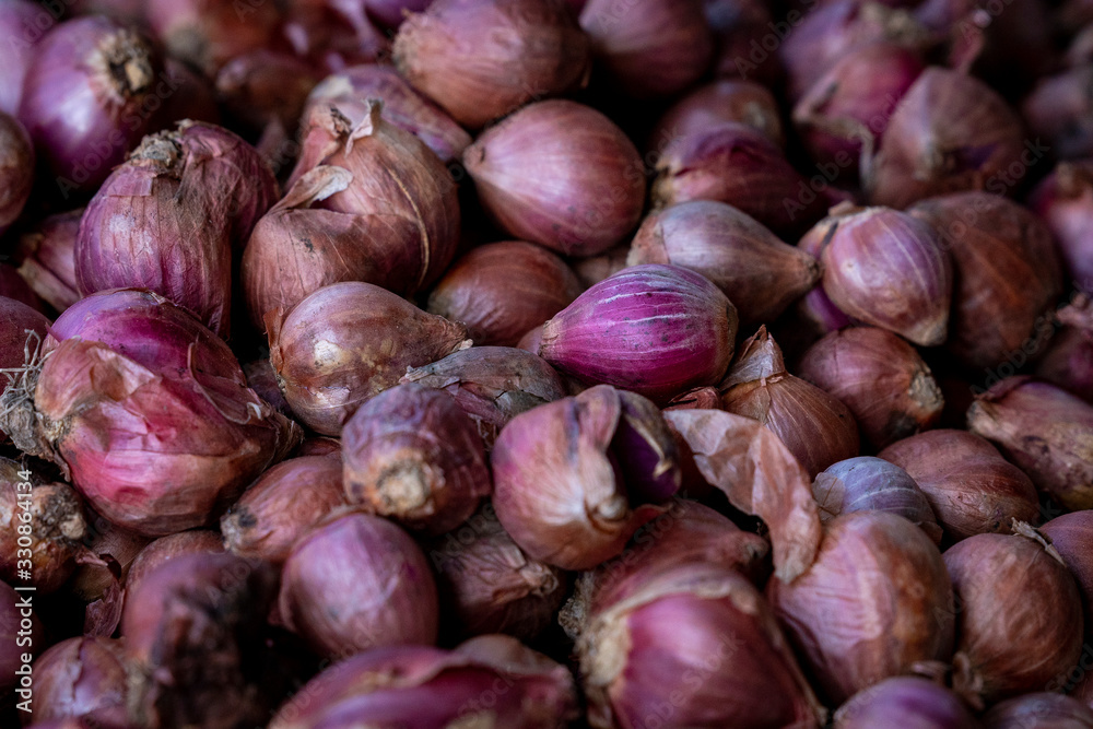 Colorful purple onions are one of the fresh produce products at an outdoor asian market in Bali, Indonesia. Colorful purple onions are one of the fresh produce products at an outdoor asian market in Bali, Indonesia.
